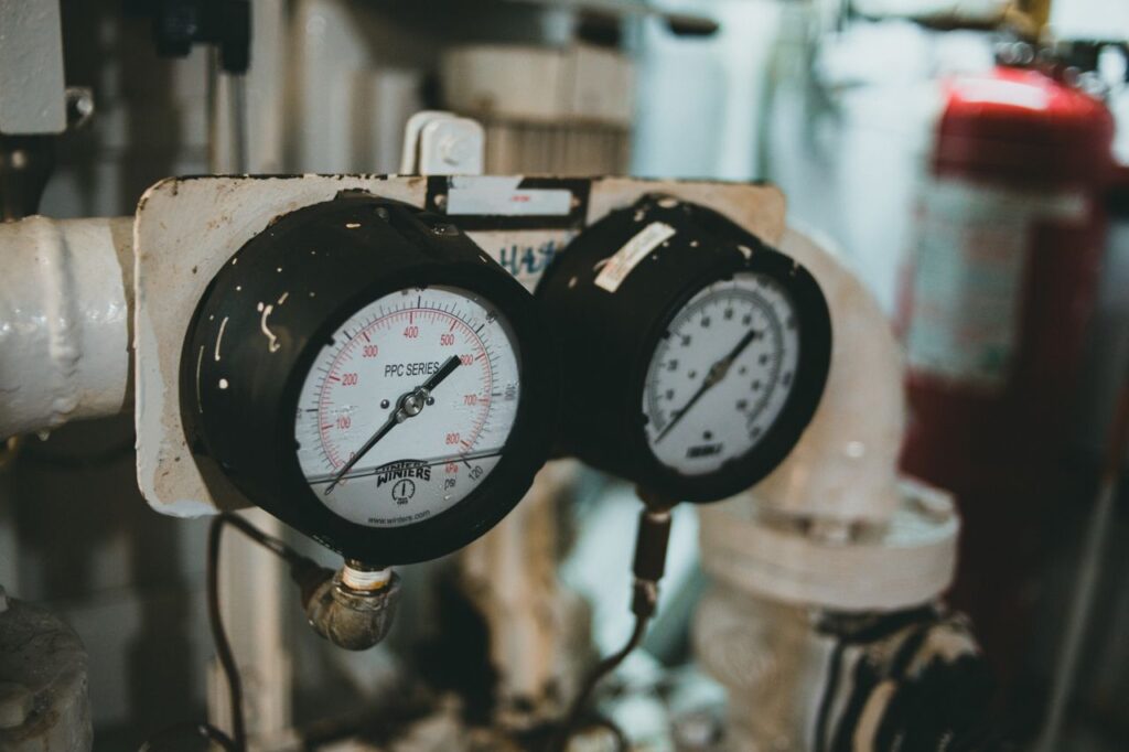 about-us Detailed close-up of industrial pressure gauges set against a blurred machine background.
